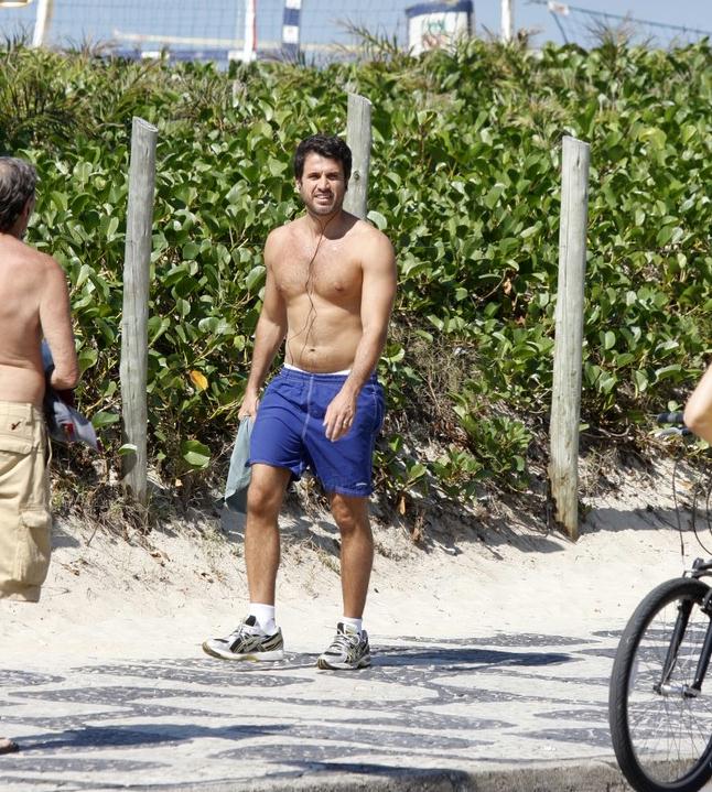 Sem camisa, Eriberto Leão caminha na orla do Leblon