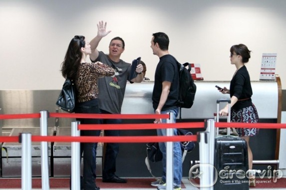 Boninho acena para fotógrafo em aeroporto