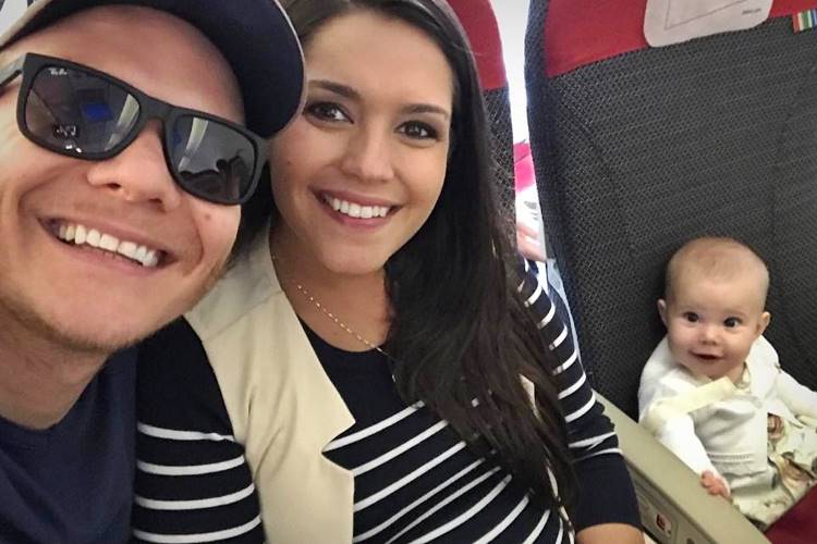 Grávidos, Thais Fersoza e Michel Teló posam com Melinda sorridente dentro de avião