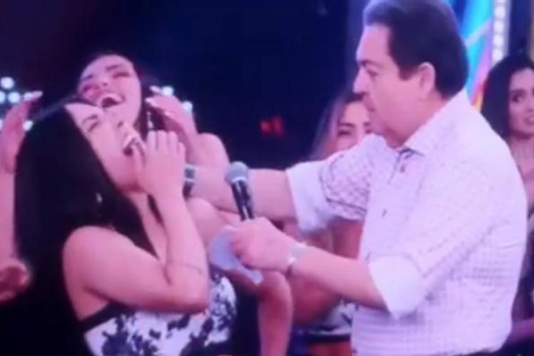Faustão bate com microfone nos dentes de bailarina
