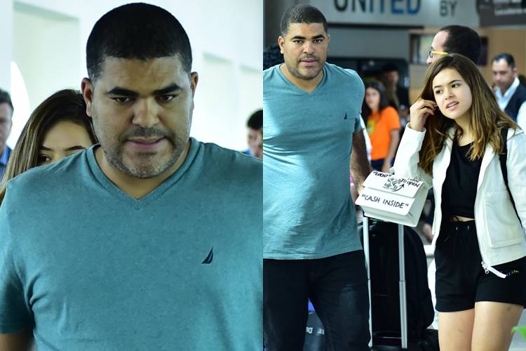 Maisa se esconde atrás do pai e evita fotos ao desembarcar em São Paulo