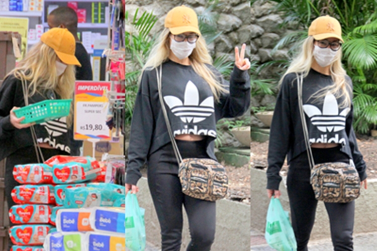 De máscara, Danielle Winits vai às compras no Rio