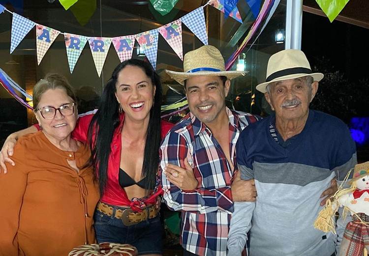 Sorridente, Zezé Di Camargo posa ao lado dos pais em clima de festa junina