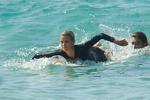 Carolina Dieckmann aproveita gravação na praia para surfar