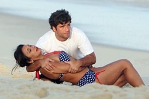 De biquíni de bolinhas, Dira Paes grava com Bruno Gagliasso na praia