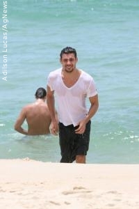 Cauã Reymond entra no mar de roupa