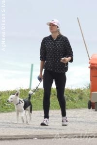 Ellen Jabour caminha com seu cachorro na orla da Barra