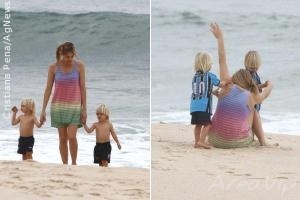 Fernanda Lima brinca com os gêmeos na praia